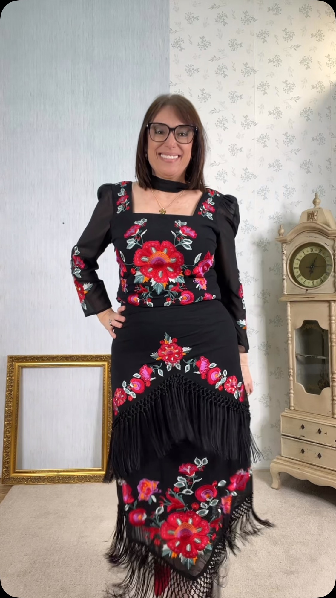 Mujer con vestido negro decorado con flores rojas